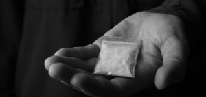 Police say 21 year old walked out of known drug base with suspected cocaine